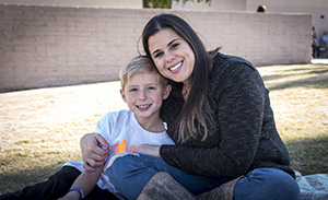 Mother hugs elementary aged child